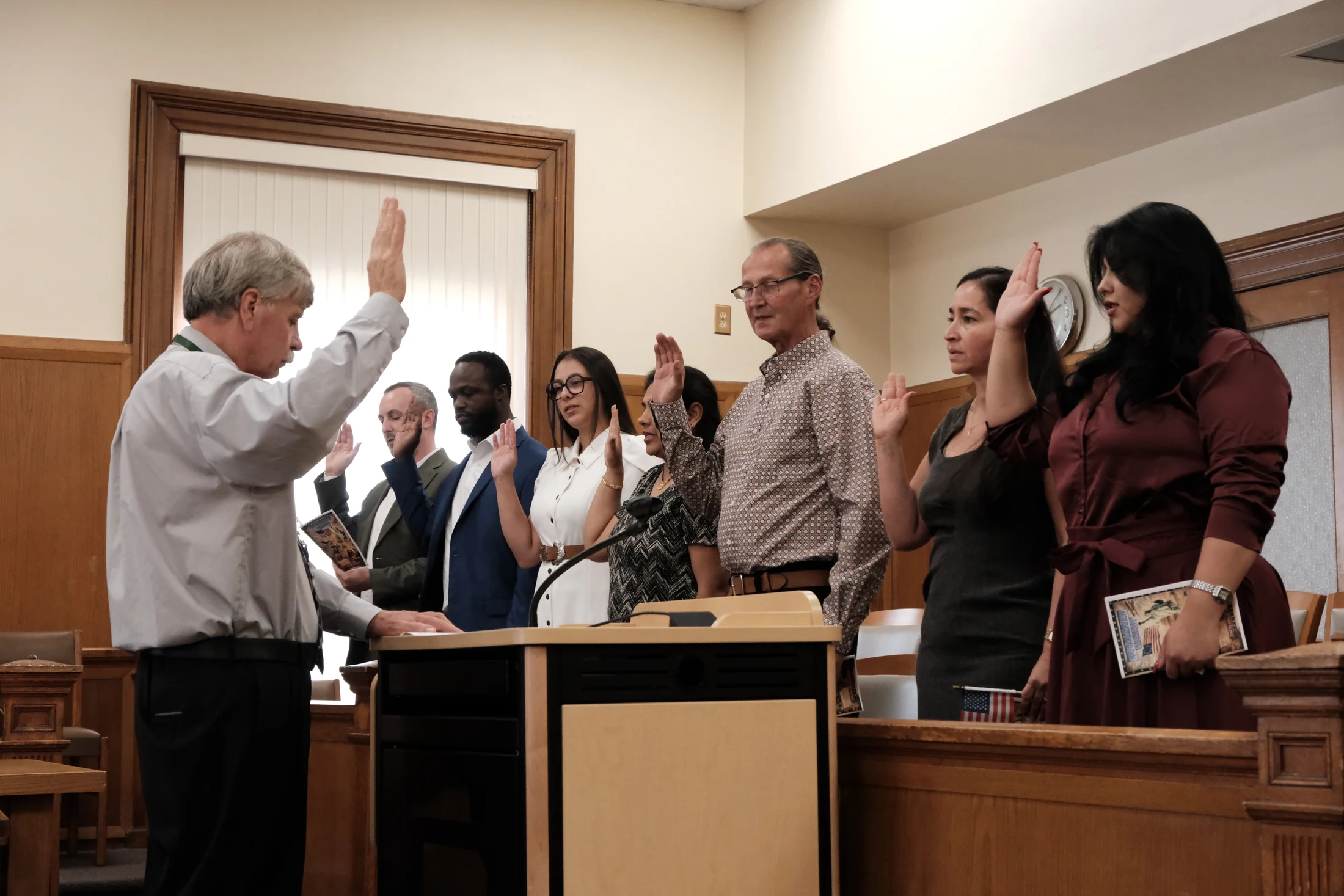 County Clerk Russell Reeves leads seven Sullivan County residents in the Oath of Allegiance during a naturalization ceremony August 5 at the Sullivan County Courthouse in Monticello.
