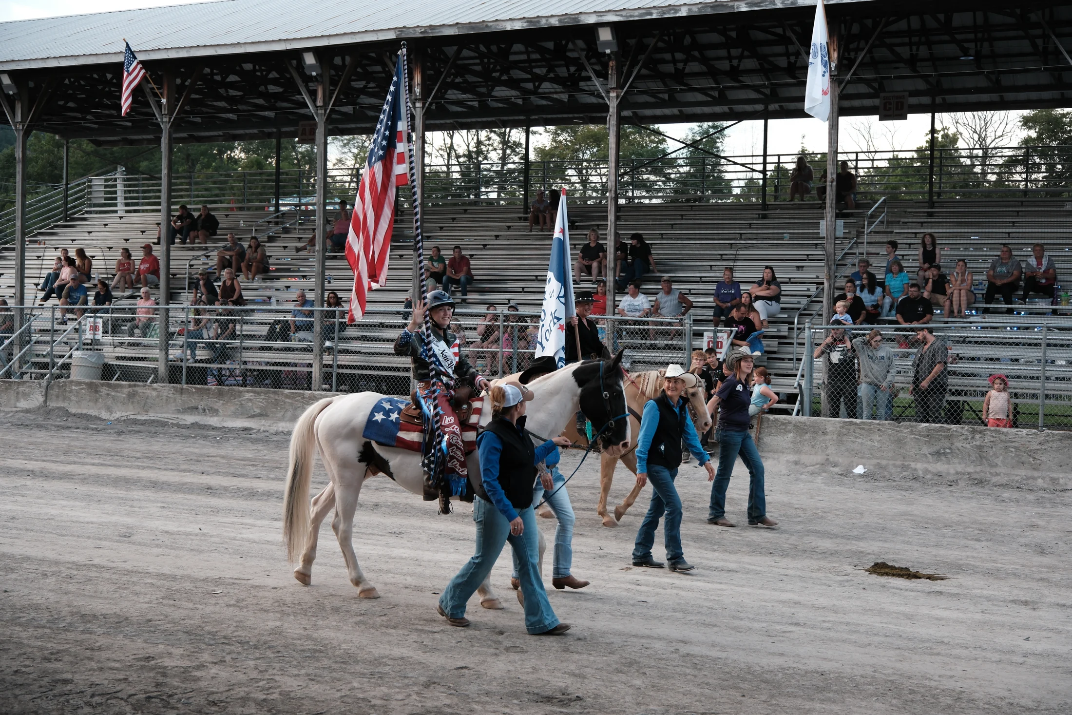 Little Miss Rodeo New York 2026 Alexa Banks carries the American flag while riding Scotty Too Hottie during the Heroes Parade at the Delaware County Fair.